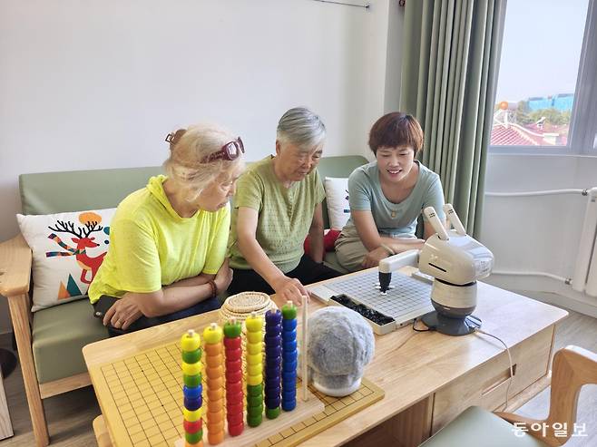 22일 중국 베이징의 한 ‘양로역참’(노인 돌봄센터)에서 노인들이 로봇과 오목을 두며 여가 시간을 보내고 있다. 베이징=김철중 특파원 tnf@donga.com