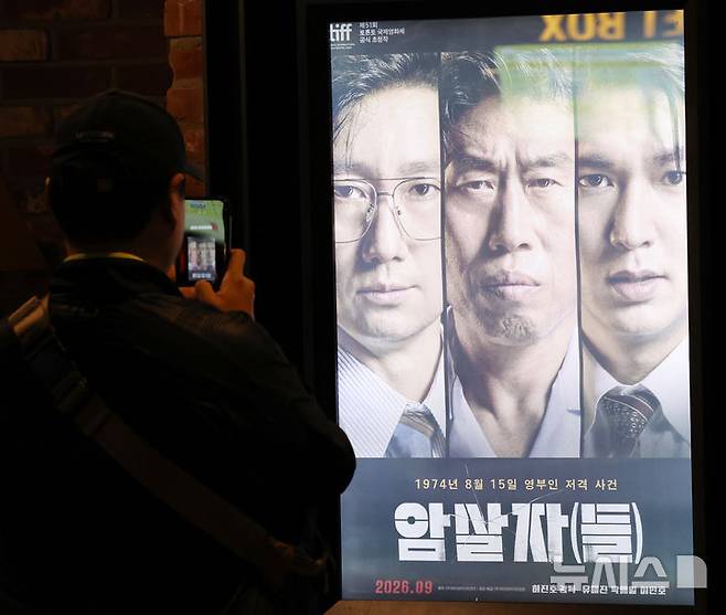 [서울=뉴시스] 박주성 기자 = 29일 서울의 한 영화관에 '암살자(들)' 포스터가 걸려 있다.  이날 육영수 여사 피격 사건을 소재로 한 영화 '암살자(들)'를 둘러싼 역사 왜곡 논란과 관련해 이종배 전 국민의힘 서울시의원이 영화 제작진이 명예훼손 혐의로 경찰에 고발했다. 2026.09.29. park7691@newsis.com