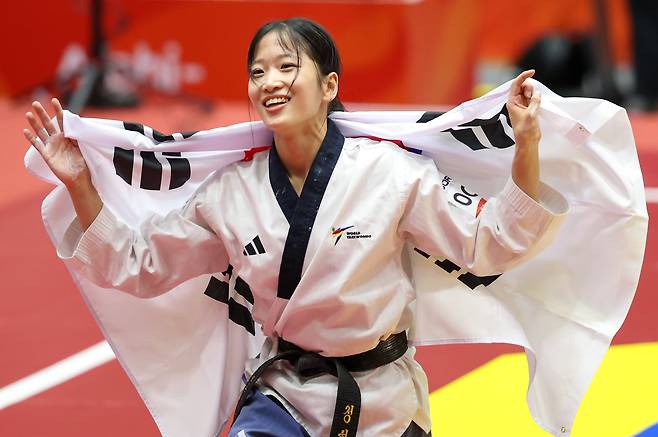대한민국 정하은이 1일 일본 도요하시 체육관에서 열린 2026 아이치·나고야 아시안게임 태권도 여자 개인 품새 결승전에서 금메달을 확정 짓자 태극기를 둘러멘채 기뻐하고 있다./뉴스1