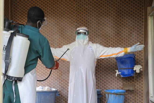 콩고민주공화국(민주콩고) 동부 북키부주 베니의 에볼라 환자 치료 센터에서 보호복을 입은 의료진이 동료에게 소독을 받고 있다. 2026.9.26 AP 연합뉴스