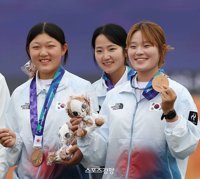 강연서, 박정윤, 박예린이 30일 아이치현 오카자키 중앙종합공원 다목적 광장에서 열린 2026 아이치·나고야 아시안게임 양궁 컴파운드 여자 단체전 시상식에서 동메달을 목에 걸고 있다. 2026.9.30. 오카자키｜강윤중 선임기자