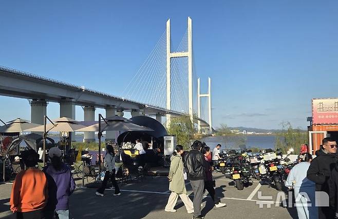 [베이징=뉴시스] 박정규 특파원 = 오는 6일 개통설이 나오고 있는 신압록강대교 북단 아래 공터에서 5일 오후 방문객들이 지나가고 있다. 2026.10.05 pjk76@newsis.com