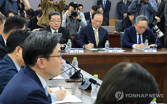 입장하는 이억원 금융위원장 (서울=연합뉴스) 최재구 기자 = 4일 정부서울청사에서 열린 최근 침해위협 대응 전금융권 긴급 점검회의에서 정상혁 신한은행장(오른쪽부터), 이환주 KB국민은행장, 이호성 하나은행장이 이억원 금융위원장의 발언을 경청하고 있다. 2026.10.4 jjaeck9@yna.co.kr