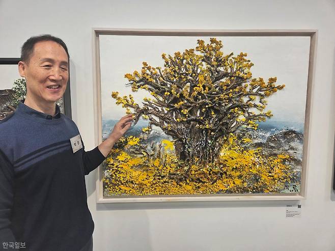 박환 작가가 은행나무를 표현한 자신의 작품 '경이로운 삶' 앞에 서 있다. 겨울을 나기 위해 잎을 떨구는 은행나무에 미래를 위한 '내려놓음'의 의미를 담았다. 나민서 기자