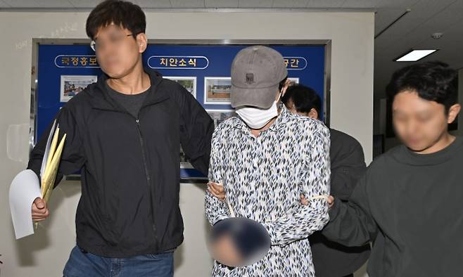 전남광주 나주의 한 주택에서 지인인 60대 부부를 살해한 혐의를 받는 50대 A(가운데)씨가 8일 오전 조사를 위해 광주 동부경찰서에서 나와 나주경찰서로 호송되고 있다. 2026.10.8 뉴시스