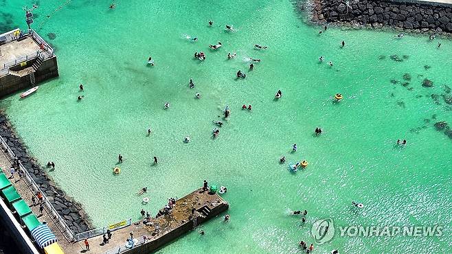 폭염특보 제주서 물놀이 하는 피서객 (제주=연합뉴스) 제주시 한경면 판포리 판포포구에서 피서객이 물놀이를 즐기는 모습.[연합뉴스 자료사진]
