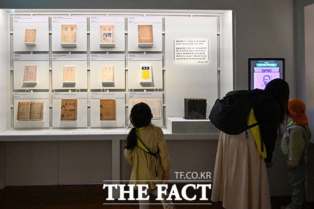 전시된 조선어학회 기관지 '한글'과 '보물 조선말 큰사전 원고'를 바라보는 어린이.