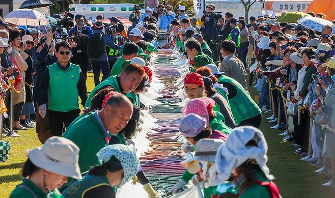 14일 오후 이천시 복하천 수변공원에서 열린 '제25회 이천쌀문화축제'에서 600m 무지개 가래떡을 만들며 즐거운 시간을 보내고 있다. /전광현 기자 maggie@incheonilbo.com