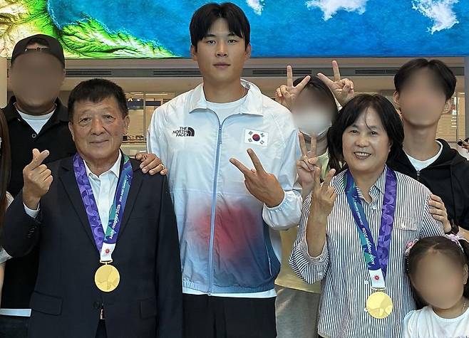 지난달 27일 아이치-나고야 아시안게임에서 2개의 금메달을 딴 김효빈 선수(가운데)가 공항에 마중나온 최현숙 원장(사진상 김 선수 오른쪽)과 이공헌 대표(김 선수 왼쪽) 부부에게 각각 금메달을 걸어줬다. 김 선수는 생후 9개월부터 최 원장이 운영하는 시설에서 컸다. [사진 김효빈]