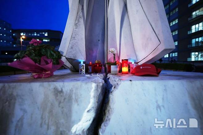 [로마=AP/뉴시스] 12일(현지 시간) 교황 레오 14세가 입원할 이탈리아 로마의 아고스티노 제멜리 종합병원 내 요한 바오로 2세 전 교황 동상 아래 레오 14세 교황의 쾌유를 기원하는 꽃과 촛불이 놓여 있다. 교황은 폐선암이 확인돼 오른쪽 폐의 하엽을 절제하는 수술을 받았다. 2026.10.14.