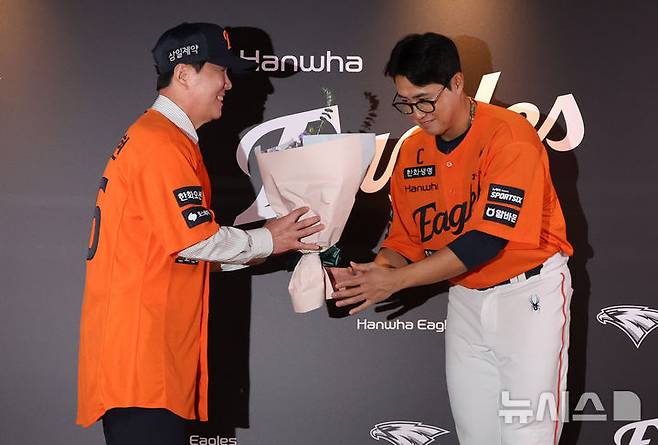 [대전=뉴시스] 배훈식 기자 = 류지현 한화이글스 신임 감독이 16일 오후 대전 중구 대전한화생명볼파크에서 열린 취임식에서 주장 채은성으로부터 꽃다발을 받고 있다. 2026.10.16. dahora83@newsis.com
