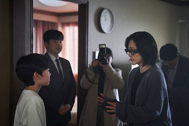 영화 <실낙원>의 ‘소영’(김현주)이 VR 안경을 끼고 아들 ‘선우’(유지완)를 바라보고 있다. 뒤는 참관 중인 트랜스휴먼사 직원과 기자들. CJ ENM 제공