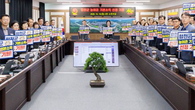 합천군 간부 공무원들이 19일 오전 간부회의에서 농어촌기본소득 선정을 기원하는 팻말을 들어보이고 있다./합천군/