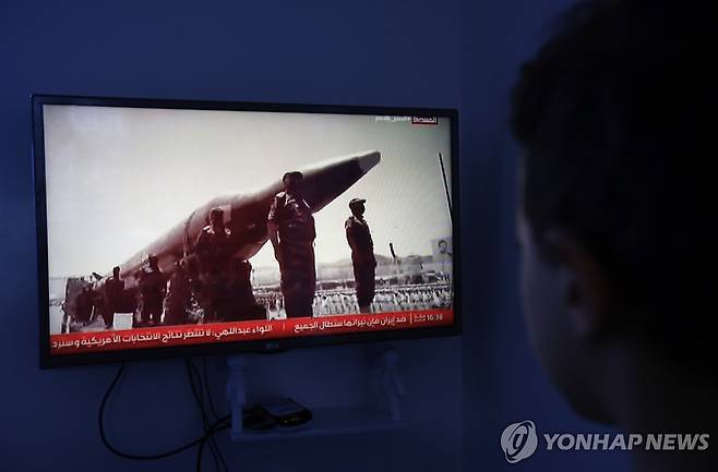 예멘 사나에서 한 시민이 최근 이어지는 예멘 교전 사태와 관련해, 미사일 주변에 도열한 후티 반군 전투원들의 모습이 방영되는 TV 화면을 지켜보고 있다.[EPA 연합뉴스. 재판매 및 DB 금지]