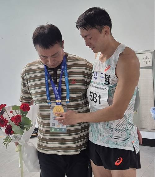 지난 19일 제주 강창학종합경기장에서 열린 전국체전 남자 일반부 400m 허들 경기에서 우승을 차지한 대구의 김주호가 자신의 스승인 권혁찬 감독에게 금메달을 걸어주며 눈물을 흘리고 있다. 권 감독도 함께 눈시울을 붉혔다.