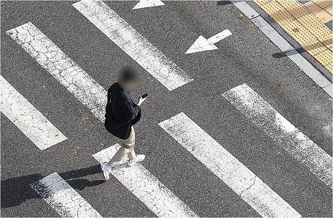 휴대전화를 보는 사람. 본 기사 내용과 직접 관련 없음. [연합뉴스 자료사진]