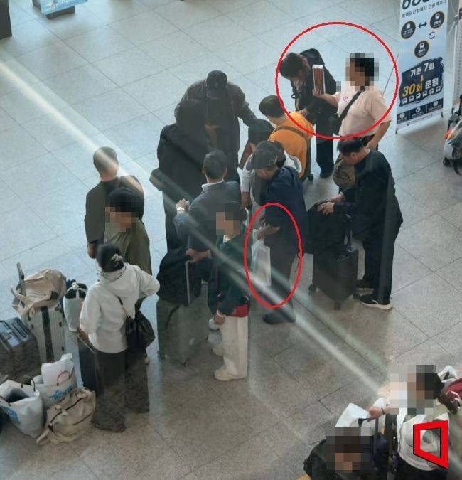 지난 13일 평택·당진항 국제여객터미널에서 중국인 관광객들이 면세로 가져온 술과 담배를 현장 관계자들이 수거해 흰색 봉투와 대형 가방에 옮겨 담고 있다. 김희윤 기자