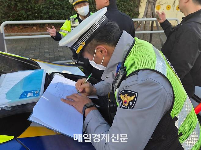22일 오전 서울 송파구 신가초 앞에서 벌어진 음주운전 단속 현장에서 경찰이 음주 측정 사용 기록을 작성하고 있다. [조병연 기자]