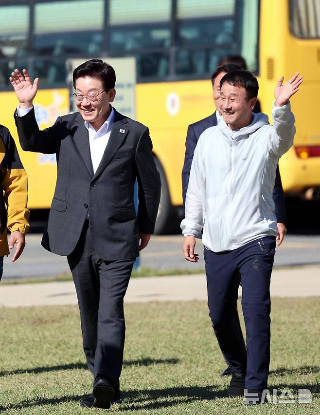 [익산=뉴시스] 김진아 기자 = 이재명 대통령과 한병도 더불어민주당 원내대표 22일 전북 익산 왕궁초등학교에서 열린 가을 행복학교 체육한마당에 입장하며 학생들에게 손 인사를 하고 있다. 2026.10.22. bluesoda@newsis.com