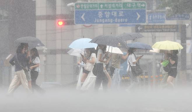 지난 17일 대구 중구 동성로에서 시민들이 우산을 쓰고 쏟아지는 장맛비를 피하며 이동하고 있다. /연합뉴스