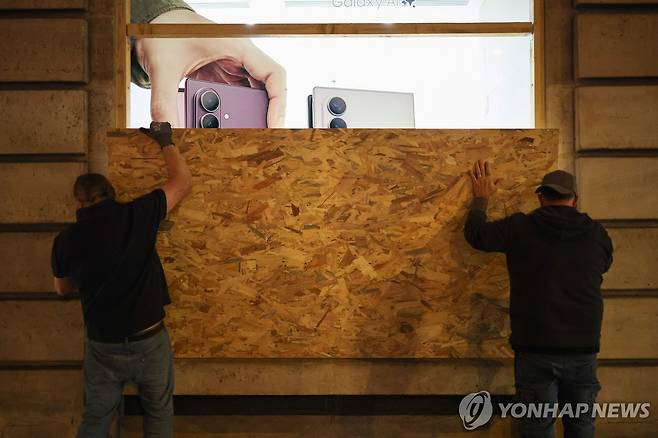 23일 파리 삼성전자 매장에서 파손 방지를 위해 나무판을 설치하는 모습 [AFP=연합뉴스. 재판매 및 DB 금지]