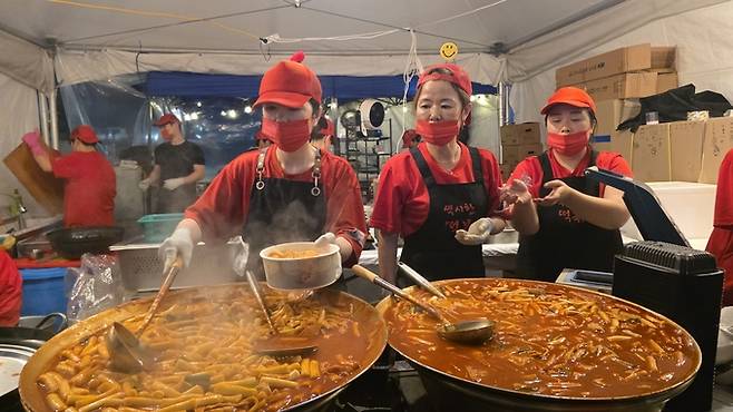 ▲ 커다란 철판 두 개에서 빨간 떡볶이가 끓어오르고, 상인들의 손길은 쉴 틈이 없다. 떡볶이보다 더 뜨거운 건 손님맞이 열기다. 김민규 기자