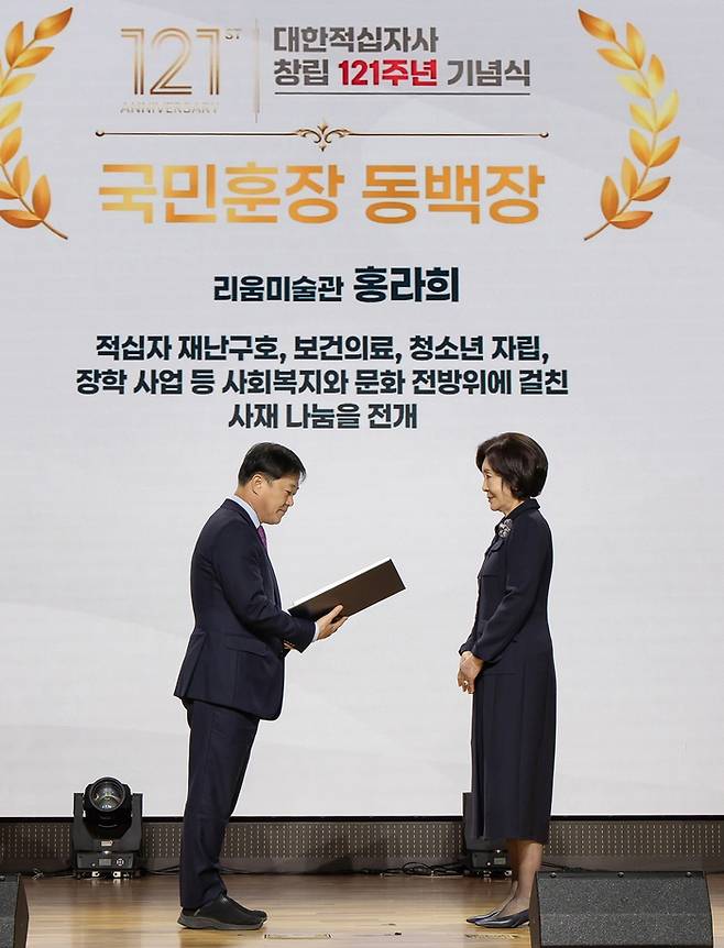 홍라희 리움미술관 명예관장이 26일 서울 중구 우리은행 본점에서 열린 대한적십자사 창립 기념식에서 이형훈 보건복지부 제2차관으로부터 국민훈장 동백장을 수여받고 있다. [리움]