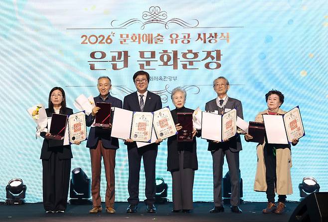 [서울=뉴시스]  26일 서울 서대문구 모두예술극장에서 '2026년 문화예술 유공 시상식'이 열렸다. 사진은 은관 문화훈장을 수훈한 정상화 딸 정인선씨(왼쪽부터), 만화가 이현세, 최휘영 문체부 장관, 배우 박정자, 전무송, 시인 유안진.  (사진 = 문화체육관광부 제공) 2026.10.26. photo@newsis.com  *재판매 및 DB 금지