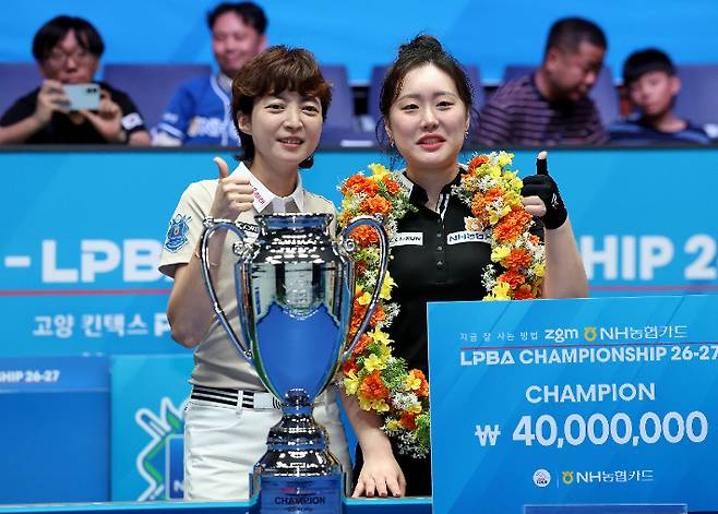'엄마 멋있지?' 임정숙(왼쪽)이 26일 경기도 '고양 킨텍스 PBA 스타디움'에서 마무리된 '지금 잘 사는 방법 zgm NH농협카드 PBA 챔피언십' 여자부 결승 뒤 우승한 후배 김보미와 기념 촬영을 한 모습. 관중석 오른쪽이 남편 이종주와 아들 연우 군. PBA