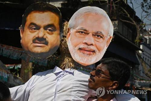 2023년 모디 인도 총리(오른쪽)와 아다니 회장의 사진을 들고 시위하는 야당 지지자 [AFP 연합뉴스 자료사진. 재판매 및 DB 금지]