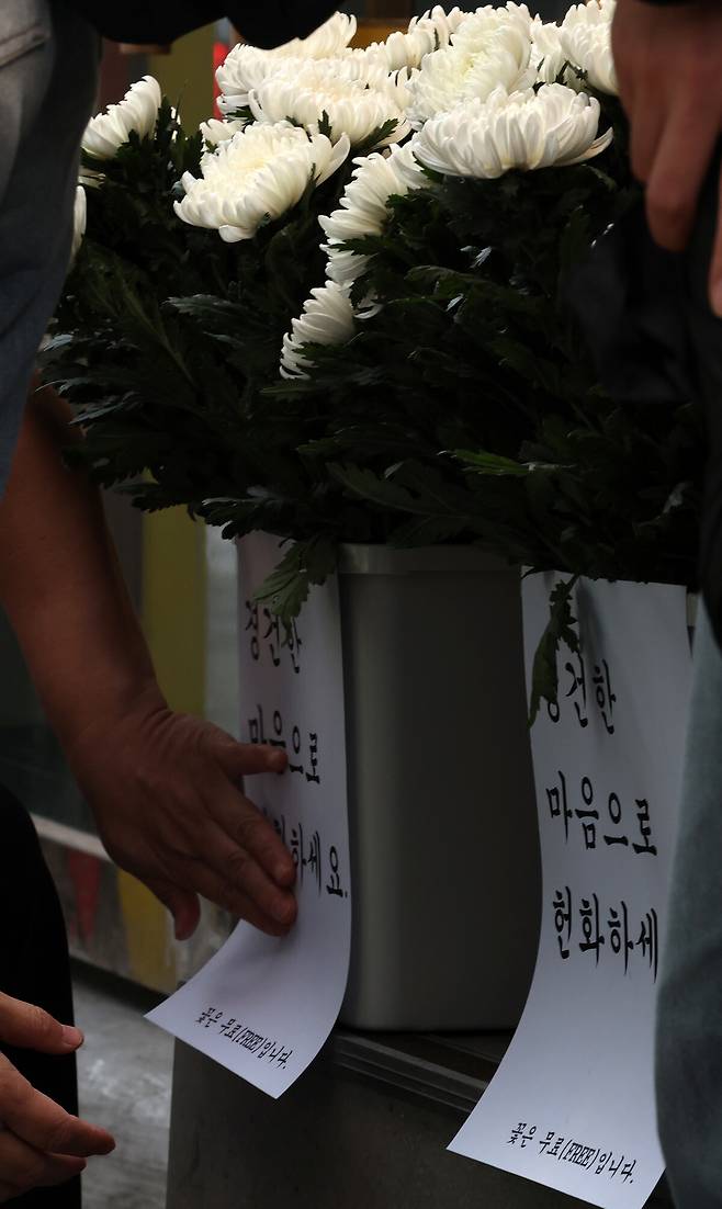 10·29 이태원참사 4주기인 29일 오전 서울 용산구 이태원 참사 현장 인근 편의점 직원이 헌화용 국화를 현장에 두고 있다. 김혜윤 기자