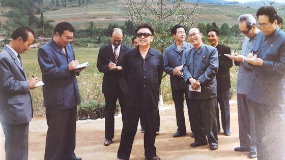 김용순 대남비서(오른쪽 끝)가 1999년 9월 자강도 낭림군에 새로 건설된 문화주택을 현지지도하는 김정일 국방위원장의 지시를 메모하고 있다. [사진집 영도자와 인민]