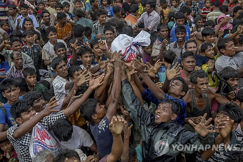 (발루칼리 난민수용소<방글라데시> AP=연합뉴스) 방글라데시로 도피한 로힝야족 난민들이 18일 발루칼리 난민 수용소 인근에서 구호차량에서 던진 구호품을 차지하기 위해 안간힘을 쓰고 있다. 미얀마군과 로힝야족 반군의 유혈충돌로 지금까지 43만명의 난민이 국경을 넘어 방글라데시로 도피했다.