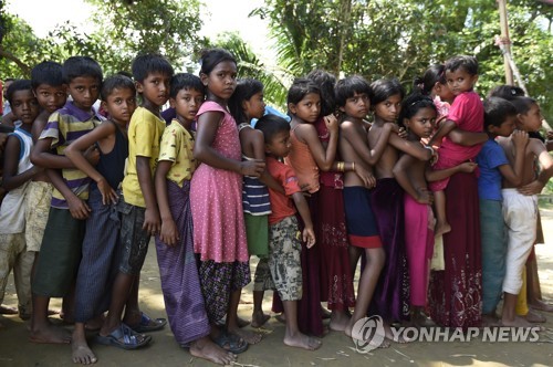 16일 미얀마와 방글라데시 사이 굼둠 지역에 있는 난민 캠프에서 로힝야족 난민 어린이들이 의약품을 받으려고 줄서 있다.[AFP=연합뉴스 자료사진]