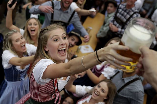 16일(현지시간) 독일 뮌헨에서 열린 184주년 옥토버페스트 맥주 축제 개막식에 한 여성이 맥주잔을 받고 있다. AP 연합뉴스