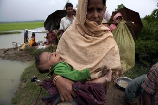 지난 6일(현지시간) 로힝야족 한 여성이 잠든 아기를 안고 미얀마 국경에 인접해 있는 방글라데시 울루부니아 지역으로 들어오고 있다.울루부니아(방글라데시) EPA 연합뉴스