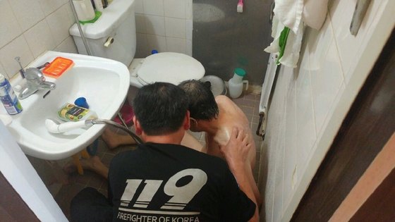 라문석 대장이 중증 지체 장애인 백모씨의 집을 찾아가 목욕을 시키고 있는 모습. [사진 본인 제공]