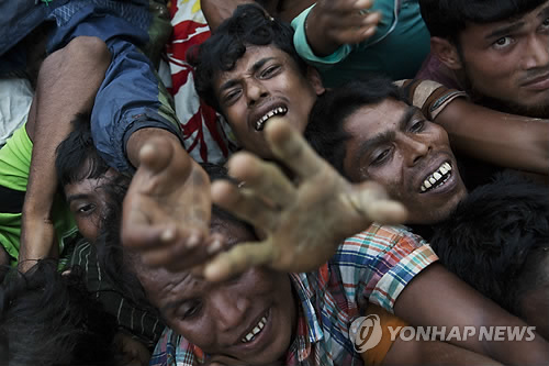 2017년 9월 20일 미얀마 이슬람교 소수민족인 로힝야족 난민들이 방글라데시 콕스바자르의 난민캠프 인근에서 배급되는 구호식량을 받기 위해 한꺼번에 몰려 든 모습. [AP=연합뉴스]