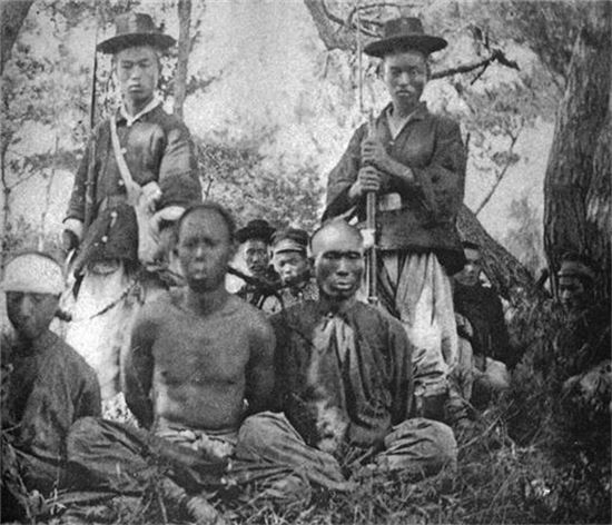 청일전쟁 당시 보초를 서고 있는 조선군과 청군포로들 모습. 사진 뒤쪽에 조선인들과 일본군 모습도 보인다. 청군 포로 중에는 조선 지방군들도 섞여있었다.(사진=위키피디아)
