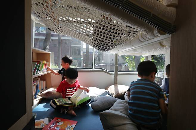 샘말 붕붕도서관을 찾은 어린이들이 책을 보고 있다. 신인섭 기자