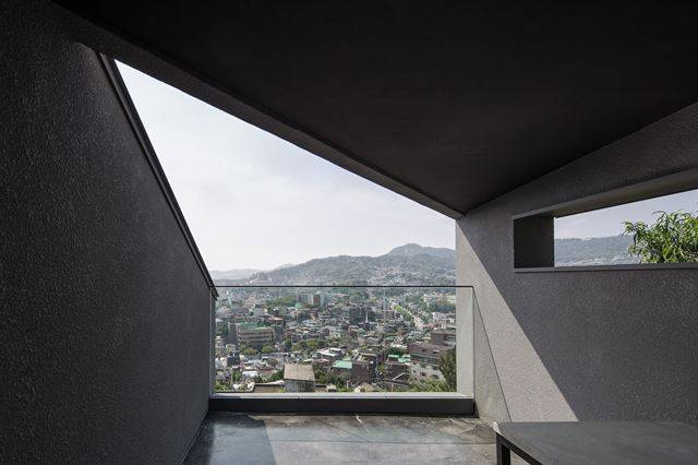 2층 테라스. 서울 시내 3분의 1이 한 눈에 들어온다. 옆집과 시선이 들락거리는 것을 꺼려한 건축주의 뜻을 따라 옆벽을 길게 뺐다. 이한울(에이플래폼) 제공