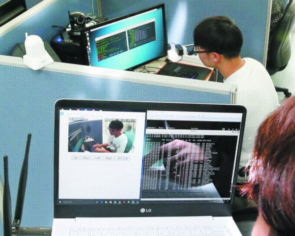 지난달 28일 서울 성북구 고려대 안암캠퍼스 산학관에 있는 보안 전문 업체 ‘노르마’ 사무실에서 노르마 관계자가 CCTV 카메라를 해킹해보이고 있다. 해커 역할을 맡은 직원(아래쪽)이 해킹 프로그램을 이용해 피해자(위쪽) 컴퓨터 모니터 위에 설치된 카메라의 ‘맥(MAC) 주소’를 알아내고, 카메라에 접속해 영상을 빼냈다. 해킹 성공까지는 3분도 걸리지 않았다./김연정 객원기자
