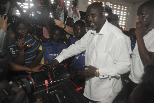 대통령 후보로 나선 라이베리아 축구영웅 조지 웨아가 대선 1차투표가 열린 지난 10일(현지시간) 수도 몬로비아 투표소에서 투표한 뒤 빠져나가고 있다. 몬로비아|AP연합뉴스
