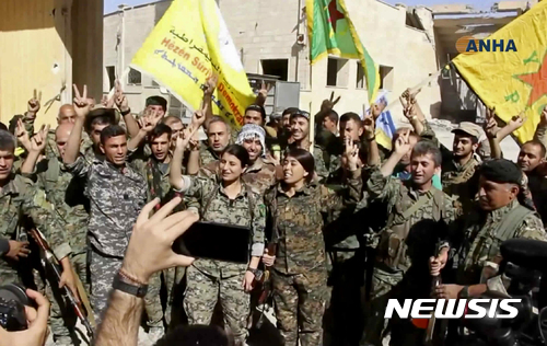 【AP/뉴시스】미군의 지원을 받는 시리아 민주군(SDF) 군인들이 17일(현지시간) 극단이슬람 무장조직 이슬람국가(IS) 수도 격이 락까를 탈환한 후 손가락으로 승리의 브이(V)자를 만들어 보이고 있다. 사진은 시리아 쿠르드계 뉴스매체인 하와르 뉴스 에이전시의 동영상을 캡처했다.2017.10.18