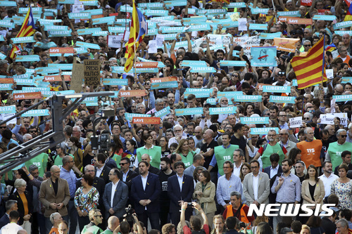 【바르셀로나=AP/뉴시스】21일(현지시간) 스페인 바르셀로나에서 카를레스 푸지데몬 카탈루냐 자치정부 수반(맨앞줄 가운데)과 정부 관료들이 참가한 가운데 카탈루냐 분리독립 찬성 시위가 진행되고 있다. 2017.10.22.