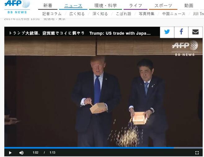 아베 신조 일본 총리가 먼저 상자째 잉어 밥을 뿌리고 있다. 트럼프 대통령은 아베 총리가 상자째 잉어 밥을 줄 때 숟가락으로 잉어 밥을 뜨고 있었다(왼쪽)/사진=AFP뉴스 캡처