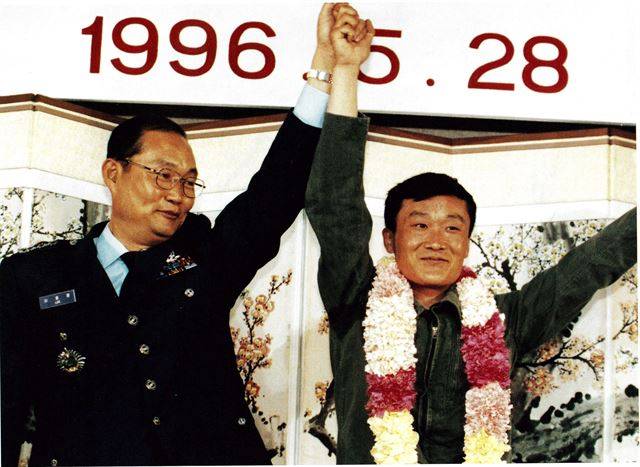 1996년 5월 전투기를 타고 귀순한 이철수(오른쪽) 대위가 1983년 귀순한 이웅평(왼쪽) 대령과 함께 기자회견에 참석해 손을 흔들고 있다. 한국일보 자료사진.