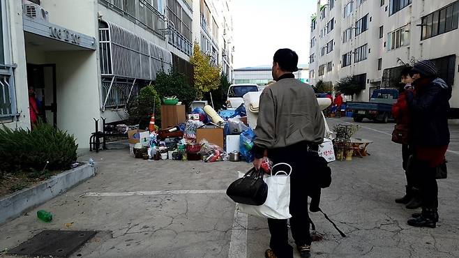 18일 오후 3시 경북 포항 북구 흥해읍 마산리 대성아파트 E동 입구 앞에서 주민이 집 안의 물건을 종이가방에 넣어 옮기고 있다.