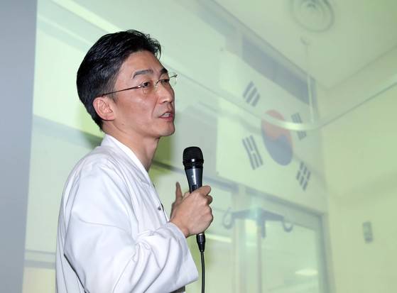 이국종 아주대병원 중등외상센터장이 22일 오전 경기도 수원 아주대병원에서 기자회견을 열고 JSA 귀순 북한병사가 치료를 받고 있는 이곳 중환자실 벽에 걸린 태극기 사진을 보여주고 있다. 박종근 기자