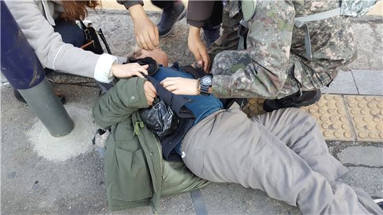 27일 서울역 광장에서 노숙인 한명이 길을 걷다 뒤로 쓰러졌다. 놀란 시민들이 황급히 달려가 응급조치를 실시했다. (사진=이승진 기자)